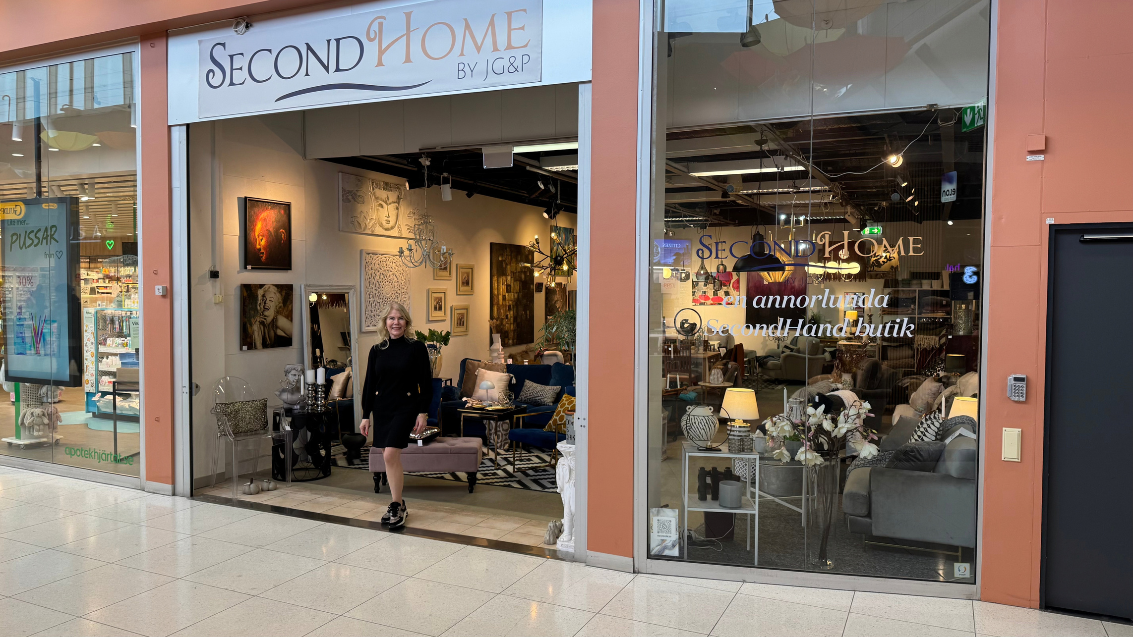 Butiksfasaden till SecondHome by JG&P i Tyresö Centrum: öppen entré med möbler, tavlor och ljuskronor, och ett skyltfönster med soffor och belysning.